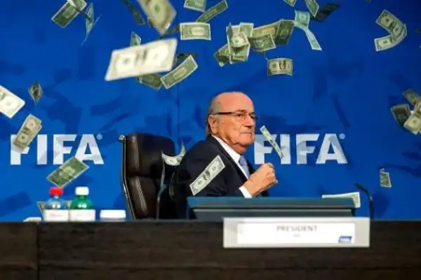 British Comedian Sprayed FIFA Pres., Sepp Blatter With Fake Dollar Bills During Press Conference [See Photos]
